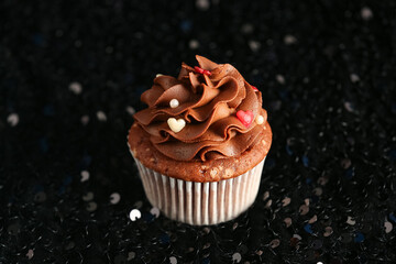 Tasty chocolate cupcake for Valentine's Day on dark blurred background