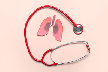 Paper lungs and stethoscope on beige background