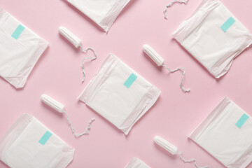 Menstrual pads and tampons on pink background