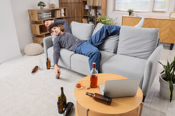 Drunk young man lying on sofa. Alcoholism concept