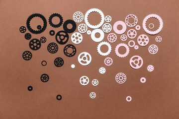 Different paper gears on brown background