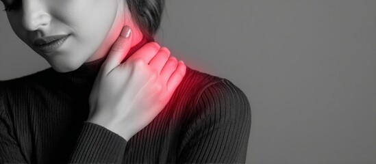 Close up of a woman experiencing neck and shoulder pain, indicated by a red highlight on a grey background