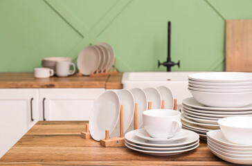 Clean white dishes on wooden table in kitchen