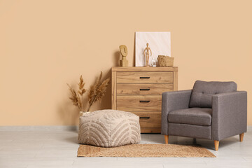 Interior of living room with armchair and home decor on commode near brown wall