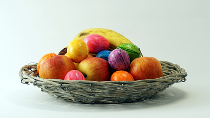 easter eggs basket with colorful easter eggs and mixed apples and a banana