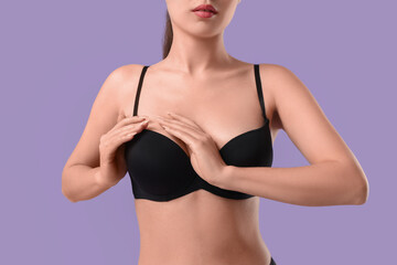 Obraz premium Beautiful young Asian woman in sexy black underwear on purple background, closeup