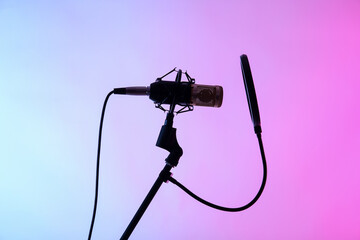 Stand with professional microphone on color background