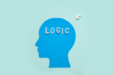 Arrow pointing at paper human head with word LOGIC on turquoise background