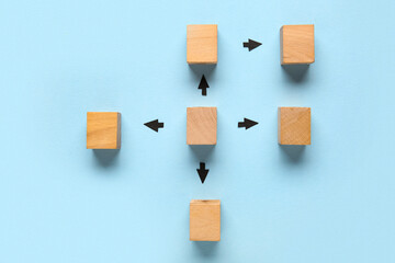 Wooden cubes with arrows on blue background. Logic concept