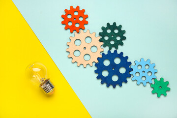 Light bulb with wooden gears on color background. Logic concept