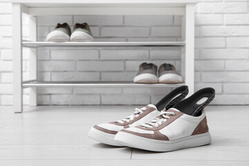 Sneakers with orthopedic insoles in hallway, closeup