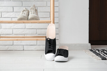 Sneakers with orthopedic insoles in hallway