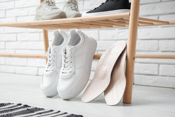 Sneakers with orthopedic insoles in hallway, closeup