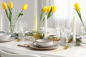 Elegant table setting with beautiful tulip flowers and candles in restaurant