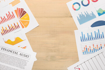 Many business graphics and diagrams on brown wooden background