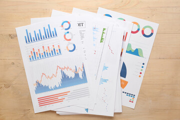 Many business graphics and diagrams on brown wooden background