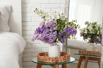 Vase with beautiful flowers on table in light bedroom, closeup