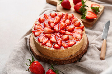Wooden board with sweet strawberry tart on white background, closeup