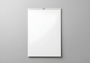 A blank, white wall calendar for scheduling and planning, against a gray backdrop.