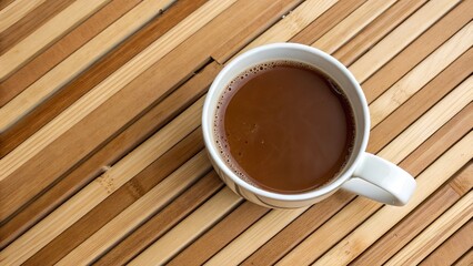 Obraz premium Coffee cup on wooden table with hot aromatic beverage and saucer