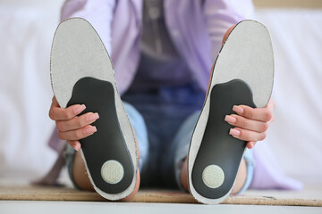 Woman with orthopedic insoles in bedroom, closeup