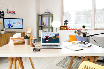 Podcaster's workplace with laptop and microphones in studio