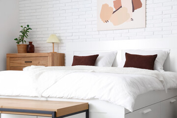 Interior of light room with big bed and commode