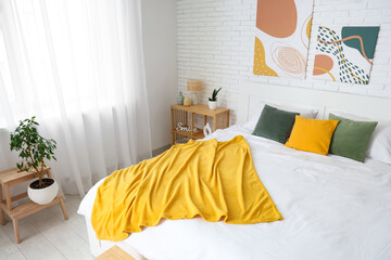 Obraz premium Interior of light room with big bed and paintings