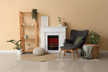 Interior of living room with fireplace, shelving unit and armchair near beige wall