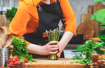 Healthy cooking with fresh vegetables by a female chef in a vibrant kitchen during the day