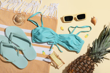 Summer composition with swimsuit, beach accessories and pineapple on beige background, closeup