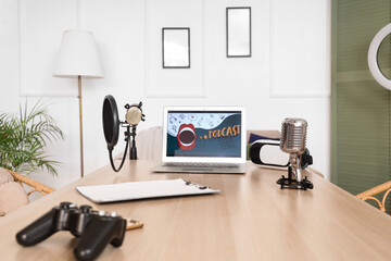 Podcaster's workplace with laptop, VR glasses and microphones in studio
