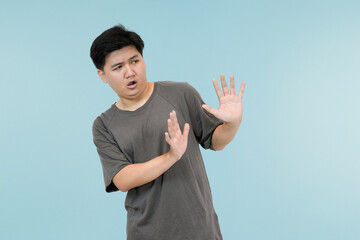 young asian man showing refusing gesture in studio background
