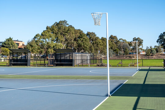 Public outdoor netball courts in a suburban Australian park. Concept of community recreation, local sports facilities, and active living infrastructure in Australia.