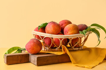 Basket of fresh peaches on yellow background