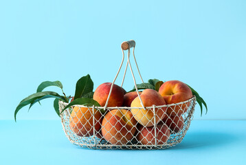 Basket of fresh peaches on blue background