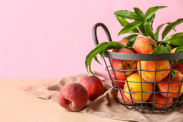 Basket of fresh peaches on pink background