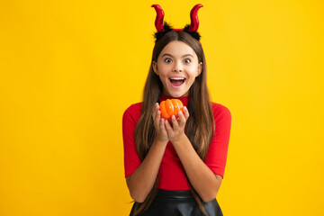 Kid girl witch celebrates Halloween. Funny little girl with pumpkin. Halloween witch girl. Cute...