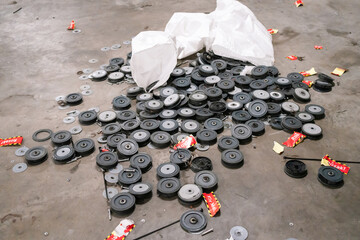 Multiple damaged black rubber wheels with bearings, scattered on a surface with some metal...