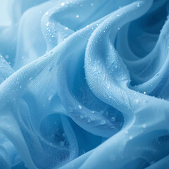 Close-up of soft flowing fabric with water droplets, creating a serene and delicate visual effect in soft blue tones.
