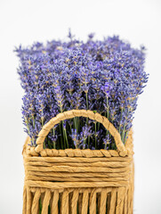 Fresh lavender flowers in a rectangular wicker basket isolated on white background.