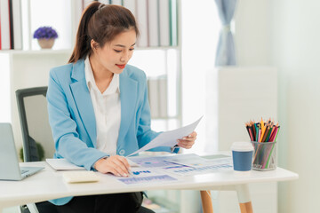 businesswoman working on laptop Successful Asian professional businesswoman in suit sitting...