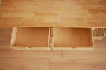 Wooden table with open drawers in a bright interior