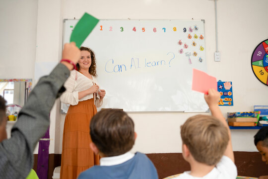 Children answer the question "Can AI learn?" using red and green cards in a preschool classroom. Interactive learning activity focused on early tech and critical thinking skills.