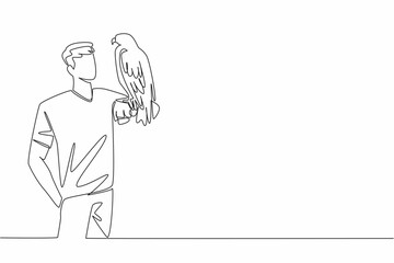 Continuous one line drawing black chested buzzard eagle perched on hand of man. Its natural habitat is in the open areas of South America. Man Holding Bird. Single line draw design vector illustration