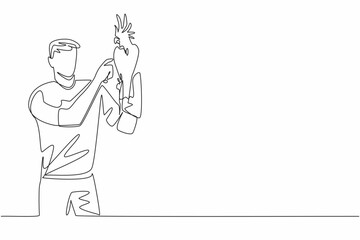 Single one line drawing cockatoo bird perched on hand of man. A bird with quite good intelligence that has beautiful feathers. Pet birds. Man Holding Bird. Continuous line design graphic illustration