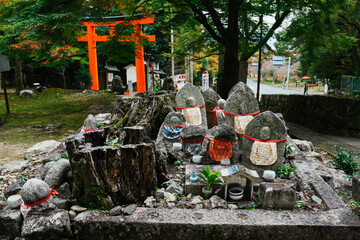 Sacred Guardians of Japan: Traditional Jizo Statues and Vibrant Torii Gate in a Spiritual Landscape