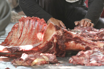 activity of a man cutting meat with a knife