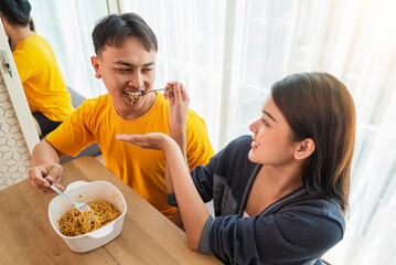 Indonesian southeast asian couple family eating noodles meal together in the dining room