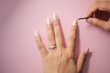 Nail care session with elegant hand on pink background